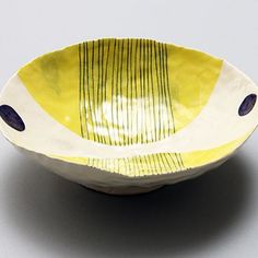 a yellow and white bowl sitting on top of a table