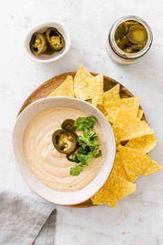 a white bowl filled with guacamole and topped with tortilla chips