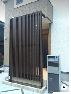 a building with a large wooden slatted door next to a parking meter on the sidewalk