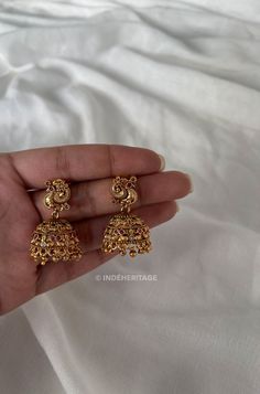 Step into the world of timeless elegance with our Jhumka Earrings. These exquisite earrings are a perfect blend of traditional design and contemporary style, making them a must-have accessory for any occasion. The jhumka style is inspired by traditional South Indian jewelry, known for its intricate craftsmanship and ornate designs. These earrings beautifully capture the essence of Indian culture and heritage, making them a timeless treasure to cherish. Whether you're attending a wedding, festival, or any special event, these Jhumka Earrings will complement your traditional attire flawlessly. They are also versatile enough to add a touch of elegance to your everyday look, making them a versatile addition to your jewelry collection. --------------------------------------------------------- C Temple Earrings, Traditional Jewelry South Indian, Temple Jewellery Jhumkas, Indian Inspired Jewelry, Jhumka Designs, Gold Earrings Indian, Gold Jhumka Earrings, Gold Jewellry, South Indian Jewelry