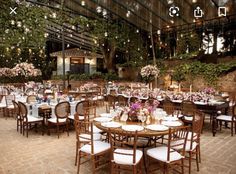 an outdoor dining area with tables and chairs set up for formal function, surrounded by greenery