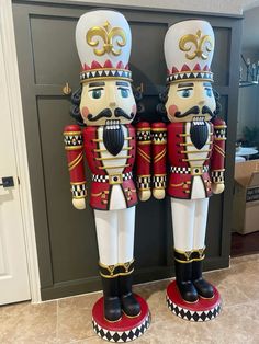 two wooden nutcrackers standing next to each other in front of a door