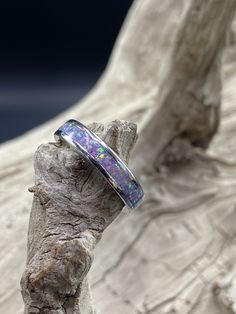 This beautiful handcrafted Stainless Steel comfort band is a real conversation starter! It features a Lavender Opal inlay in the center of the ring. The crushed Opal is placed by hand, incased in resin, and then finished and polished to a brilliant shine. Each ring I make is truly unique and no two are ever the same. These rings are made to order and are available in several sizes. Please allow 3-5 days for me to complete your ring. I do custom orders and if you have a different ring material or Opal Inlay Ring Gift, Opal Ring With Inlay Perfect For Gifts, Unique Opal Ring With Inlay For Gift, Gift Opal Inlay Ring, Adjustable Thick Band For Gift, Adjustable Thick Band Gift Bands, Silver Opal Ring With Inlay For Gift, Oval Opal Ring With Inlay For Gift, Diy Resin Ring