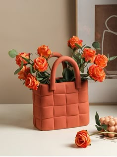 an orange bag with flowers in it sitting on a table next to eggs and other items