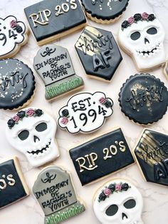 decorated sugar cookies with black and white icing on a marble countertop for halloween