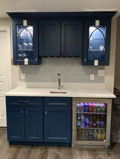 a kitchen with blue cabinets and white counter tops