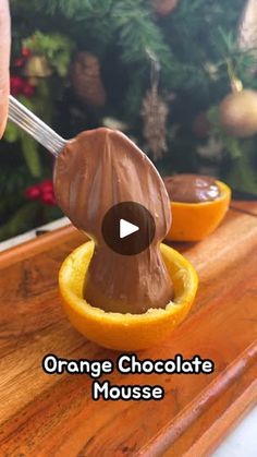 an orange is being dipped with chocolate