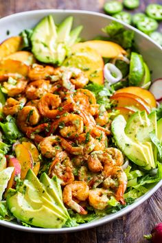 a salad with shrimp, avocado and tomatoes