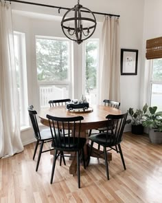 a dining room table with six chairs and a chandelier hanging from the ceiling