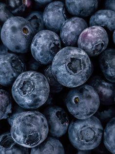 blueberries are piled high in the air and ready to be eaten by someone else