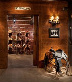 there are many horse saddles on display in this room