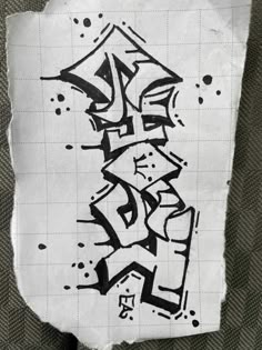 some type of graffiti on a piece of paper with black and white writing in it