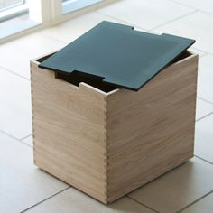 a wooden box sitting on the floor with a black sheet in it's lid