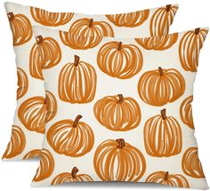 two decorative pillows with orange pumpkins on them