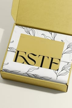 an open box with a white and yellow design on the inside that says estf