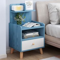 a blue and white nightstand next to a bed