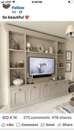 a tv is mounted on the wall in a living room with built - in shelving