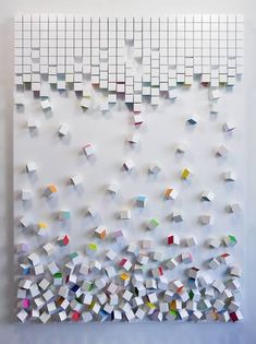 a white wall with many different colored squares on it