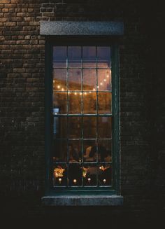 people sitting at a table in front of a window with the lights on behind them