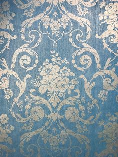 a blue and gold wallpaper with floral designs