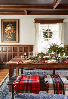 a dining room table decorated for christmas with greenery and candles on the top shelf