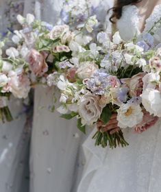 the bridesmaids are holding their bouquets with white, pink and purple flowers