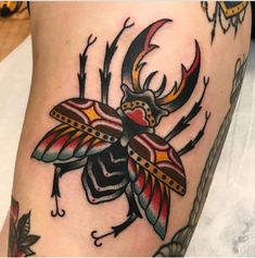 a tattoo with a beetle on it's leg and antelope in the center