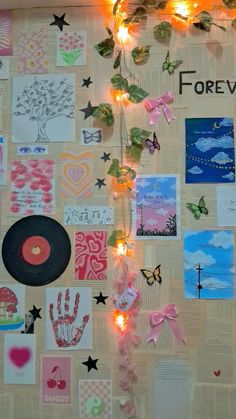 a wall covered with lots of different types of paper and lights on top of it