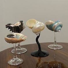 three glass vases sitting on top of a wooden table next to eachother