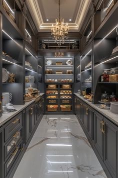 an elegant kitchen with marble flooring and gray cabinetry, along with chandelier