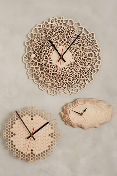 two clocks made out of wood are on the wall