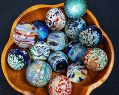 a wooden bowl filled with glass marbles