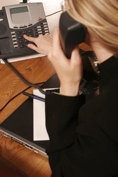 a woman is talking on the phone while sitting at her desk royalty images and stock photos