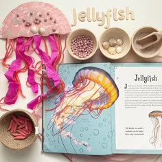 an open book with jellyfish and other items on the page next to it,