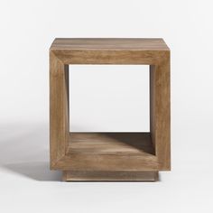 a square wooden table sitting on top of a white floor