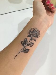 a woman's arm with a rose tattoo on the left side of her wrist