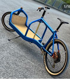 a blue bike is parked on the side of the road with its seat folded down