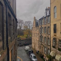 cars are parked on the side of an alleyway between two buildings, one is empty