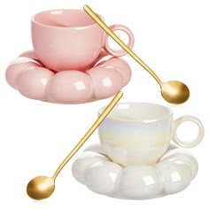 a pink coffee cup with two gold spoons on it and an opulent saucer