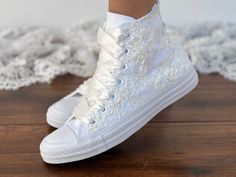 Consider these lacey sneakers like your favorite Converse, but personalized specifically for your wedding day. Forget traditional shoelaces; these white sneakers are tied with a romantic ribbon. (Choose from one of 20 different colored ribbons.) You can also personalize the heel with your initials and wedding date and add pearls to the toe cover. Or, keep it simple with the lovely lace speaking for itself. - Upper piece of durable canvas fabric - Classic toe cover made of cast rubber sole - All White Lace-up Sneakers, Cream Wedding Shoes With White Laces, White Sneakers With Laces For Bridal Shower, Low-top Wedding Shoes With White Laces, White Low-top Wedding Shoes For Bride, White Low-top Wedding Shoes For Bridal Shower, Lace-up Wedding Shoes With Laces, White Low-top Bridal Sneakers, Lace-up Lace Wedding Shoes With Lace Trim