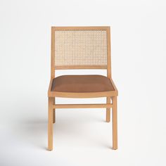 a wooden chair with brown leather seat and back cushion on a white background, side view