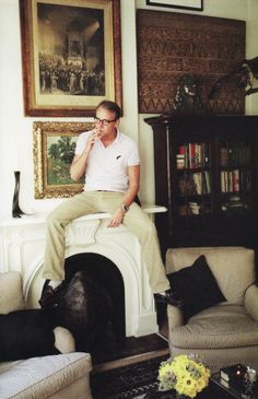 a man sitting on top of a fireplace in a living room