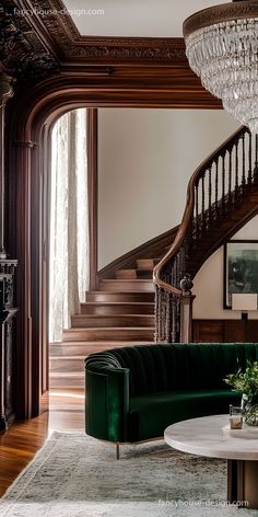 a living room with green velvet couches and chandelier