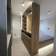 an empty room with a bed and built - in storage units on the wall next to it