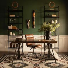 an office with green walls and leather chairs in front of a desk that has a potted plant on it