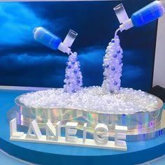 two bottles are pouring water into a display