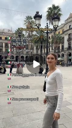 a woman is standing in the middle of a plaza with palm trees and buildings behind her