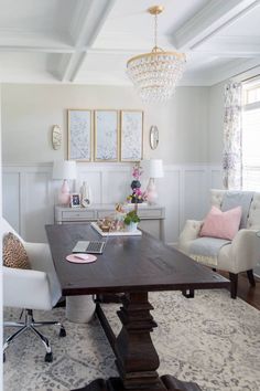 a living room filled with furniture and a chandelier above a wooden dining table