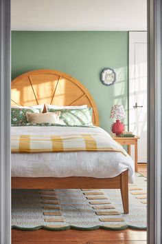 a bed sitting in a bedroom next to a wooden headboard and footstool