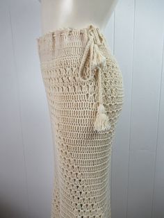 "Vintage 1970s hippy crochet skirt. Made of antique white cotton. Bohemian hippy style. Floor length with a drawstring waist. Crocheted on the bias so it is form fitting. Slight fish tail at bottom. No label. About a size medium. Actual measurements are: 32\"(adjusts bigger with drawstring) around the waist 38\" (stretches to 42\") around the hips 40\" overall length In very good condition." Bohemian Cotton Maxi Skirt For Beach, White Crochet Bottoms For Festival, Bohemian Crochet Bottoms For The Beach, Bohemian Cotton Skirt For The Beach, Bohemian Crochet Bottoms For Beach, Bohemian Cotton Skirt For Beach, Bohemian Crochet Beach Bottoms, Bohemian Crochet Lace Beach Bottoms, White Bohemian Bottoms With Crochet Trim